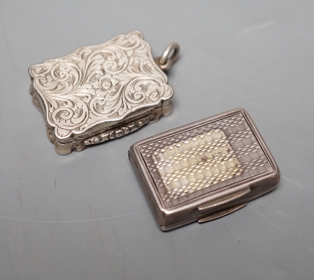 A Victorian engraved silver shaped rectangular vinaigrette, Alfred Taylor, Birmingham, 30mm, 1857 and one other silver vinaigrette by Francis Clark, 30mm, with engraved monogram.